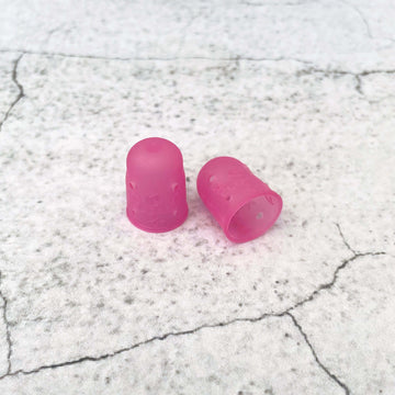 Two pink flexible rubber thimbles in size medium by Clover brand.
